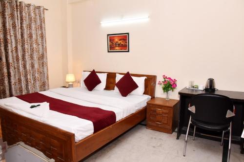 um quarto com uma cama e uma secretária com um computador em Hotel Sunshine I Couple Friendly I Budget Friendly em Gurgaon