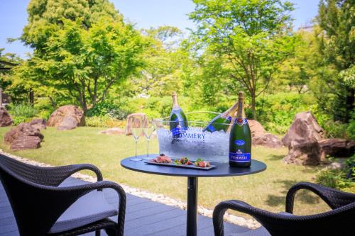 a table with wine bottles and glasses on a patio at Hotel Okura Kyoto Okazaki Bettei in Kyoto
