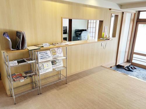 an office with a counter with a mirror and a desk at Nakaya Ryokan in Kakeyu