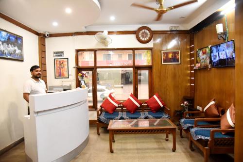 a man standing at a counter in a room at Hotel Sunshine in Gurgaon