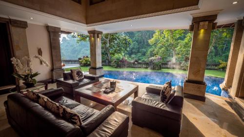 a living room with couches and a swimming pool at Viceroy Bali in Ubud