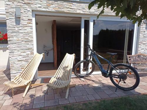 a bike parked next to two chairs on a porch at Haloze ForMe in Zavrč