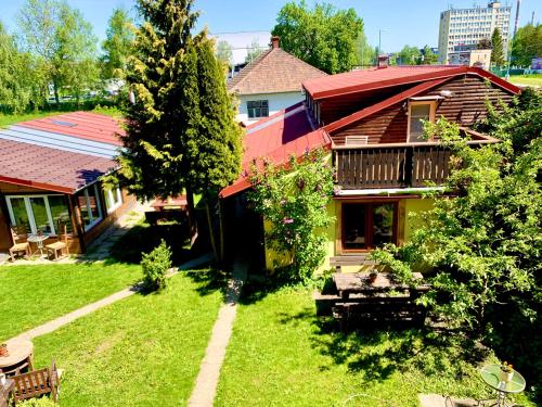 a house with a yard with a bench and a tree at Pension Aqualand in Poprad