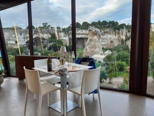 un tavolo e sedie con vista sull'anfiteatro di MOMENTO-TEATRO GRECO a Siracusa