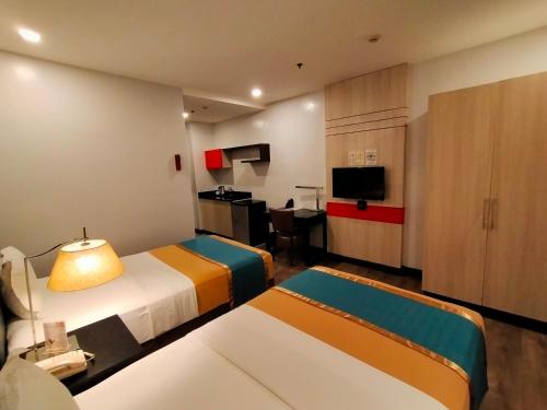 a hotel room with two beds and a kitchen at Studio 89 Katipunan QC in Manila