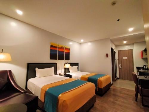 a hotel room with two beds and a couch at Studio 89 Katipunan QC in Manila