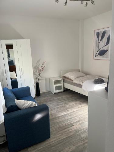 a living room with a bed and a chair at Cozy Airport Apartment in Kelsterbach