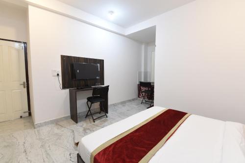 - une chambre avec un lit et une télévision à écran plat dans l'établissement OYO Ooak Hotels Delta 1, à Greater Noida