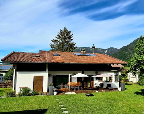 a house with a red roof and a yard at Chalet Anna in Unterwössen