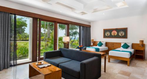 Blue Point Resort and Spa في أُلُواتو: غرفة معيشة مع أريكة وغرفة مع نوافذ