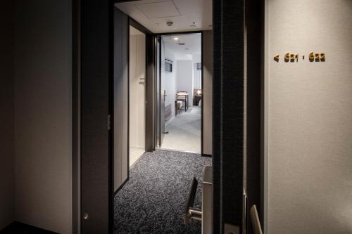 a hallway in a room with a door and a mirror at Tokyu Stay Shinjuku Eastside in Tokyo