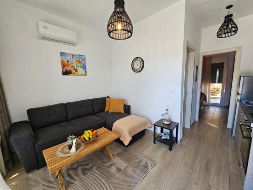 a living room with a couch and a table at Sol Greco Apartment in Skala Rachoniou
