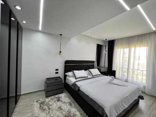 um quarto com uma cama grande e uma janela em Twin house 4 master Bedrooms premium mountain view Ras Elhekma em Ras Elhekma