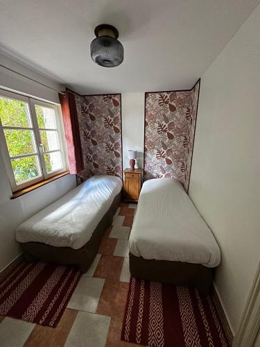 a bedroom with two beds and a window at Hôtel les Grands Chênes in Saint-Fargeau