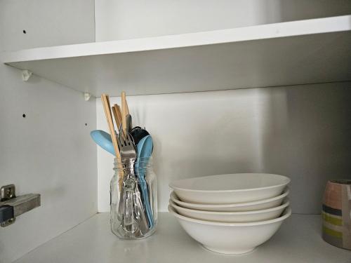 Una encimera de cocina con platos, un cuenco y utensilios. en Studio apartment Seaview Cityview, en George Town
