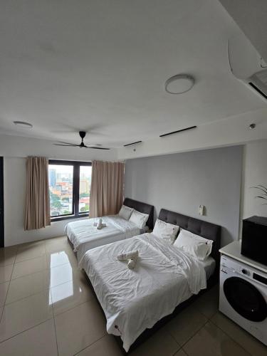 Un dormitorio con dos camas y un televisor. en Studio apartment Seaview Cityview, en George Town