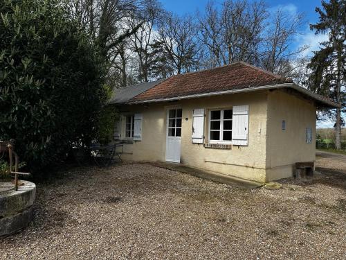 a small house sitting on top of a gravel yard at Hôtel les Grands Chênes in Saint-Fargeau