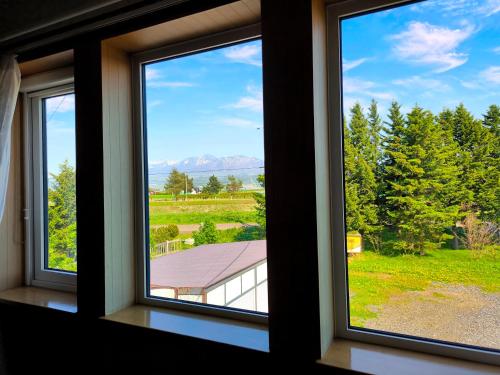 une fenêtre avec vue sur une maison dans l'établissement Other Side House, à Nakafurano