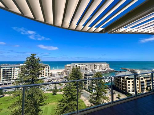 balcón con vistas al océano y a los edificios en Belle Escapes - Glenelg Skyline Penthouse, en Glenelg