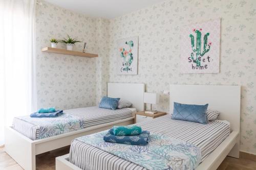 a bedroom with two beds with blue pillows on them at AB Properties - Chic House Marbella - 3 mm to Puerto Banús and Beach - Golden Mile - Direct access to Pool and Tropical Garden in Marbella