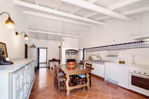 een keuken met witte kasten en een houten tafel bij Fontenoy in Tavira