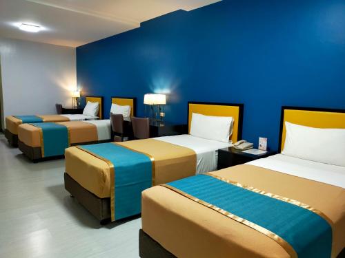 3 camas en una habitación con una pared azul en Studio 89 Katipunan QC en Manila