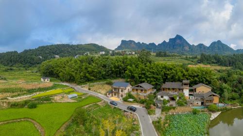 Vue aérienne d'une maison sur une colline avec une route dans l'établissement Dayong Antique Feature Resort, à Zhangjiajie