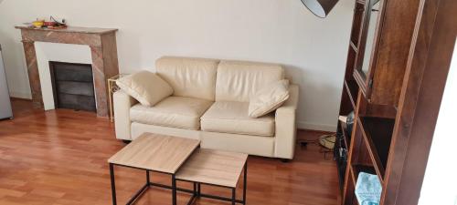 un salon avec un canapé blanc et une table dans l'établissement Le Nid d'Anatole, au Mans