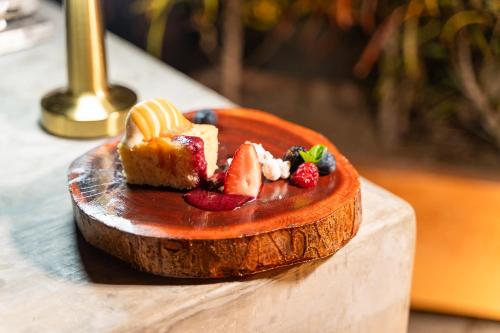 een dessert met fruit op een houten bord op een tafel bij Casa Ceiba Huatulco - Adults Only in Santa Cruz Huatulco