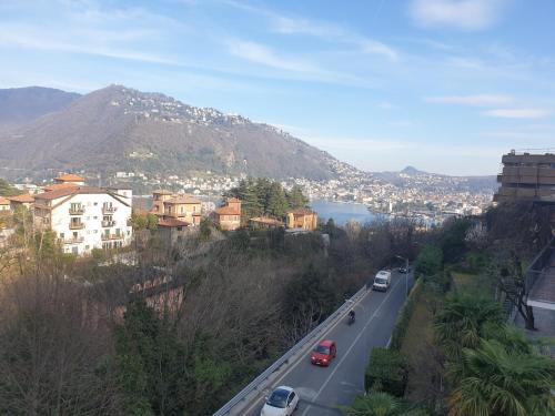 a city with cars driving down a road with a mountain at RESIDENCE VILLA ELI in Como