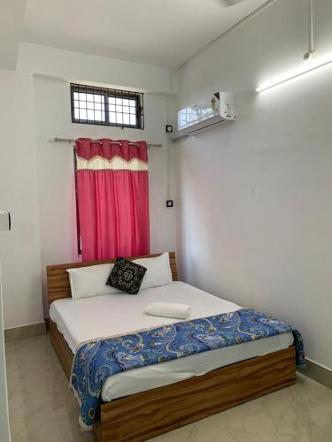 una camera con letto con tenda rossa di JP Hotel a Tezpur