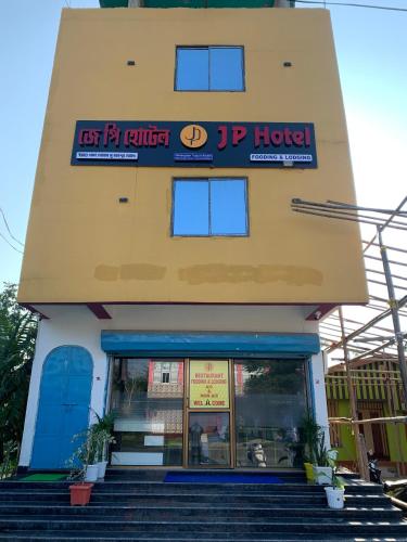 een winkel voor een gebouw met trappen voor bij JP Hotel in Tezpur