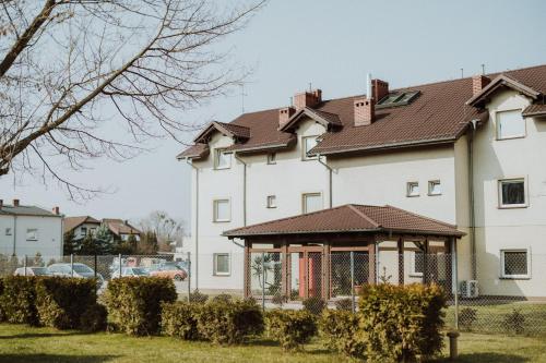 uma grande casa branca com um gazebo em Leo Hostel em Poznań