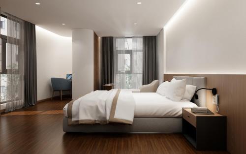 sypialnia z dużym białym łóżkiem i oknami w obiekcie River Way Hotel w Ha Long