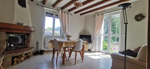 Una sala de estar con una mesa y una chimenea. en Gîte Le Clos des Vosges, en Ban-sur-Meurthe-Clefcy