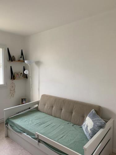- un canapé dans une chambre dotée d'un mur blanc dans l'établissement Appartement ensoleillé, à La Teste-de-Buch