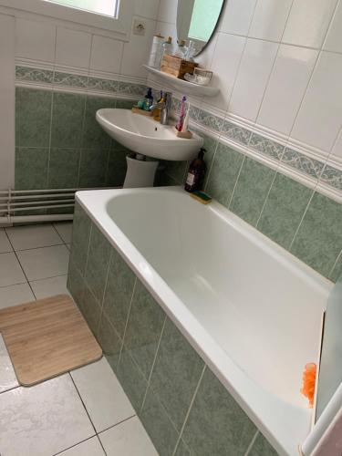 une salle de bain avec une baignoire et un lavabo dans l'établissement Appartement ensoleillé, à La Teste-de-Buch