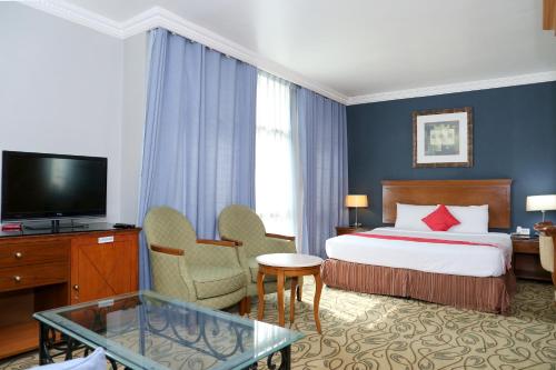 Habitación de hotel con cama y TV en City Plaza Hotel en Fujairah