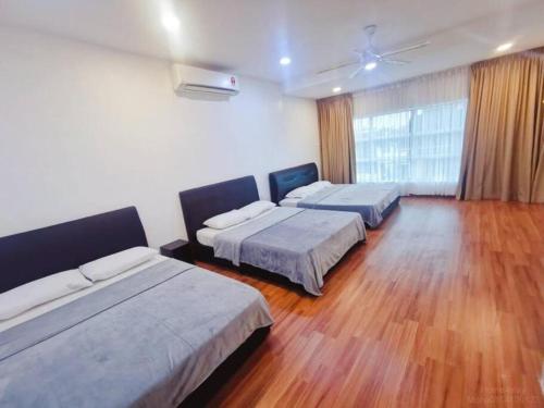 two beds in a room with wooden floors at 90 Home4Stay 2storeySemi-D gurney&beach Shopping local food in Tanjung Bungah