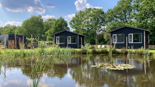 a couple of huts in the middle of a lake at Vakantiepark De Kremmer in Gasselte