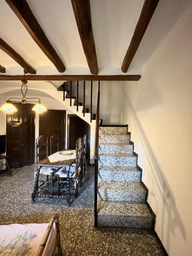 a staircase in a house with a table and chairs at Casa de Turisme Rural Riu Montsant in Bellmunt de Ciurana