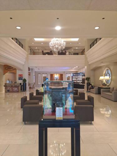 a lobby with a waiting room with chairs and a chandelier at Han Hsien International Hotel in Kaohsiung