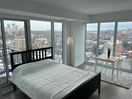 um quarto com uma cama, uma mesa e janelas em Toronto Premier INN em Toronto