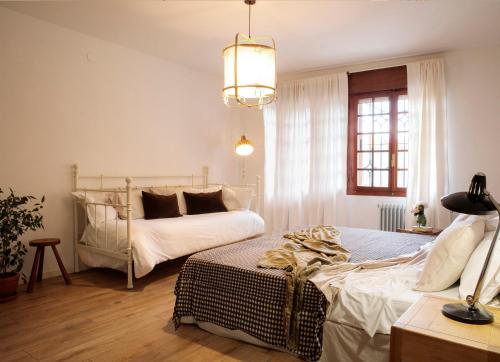 um quarto com 2 camas e um lustre em La Casa del Prado em Escalona del Prado