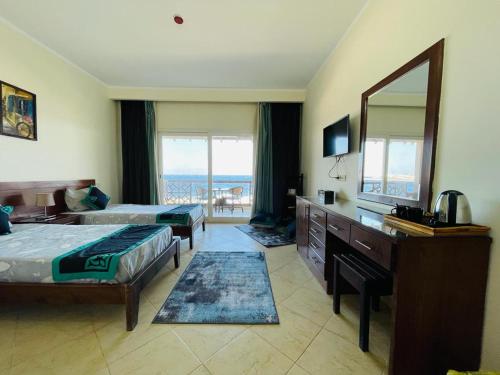 a hotel room with two beds and a mirror at Club Red Dahab Motel in Dahab
