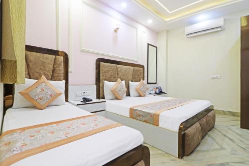 a hotel room with two beds in a room at Frankstay By Hotel Samrat Residency 10 Mints Walking Distance Nizamuddin Railway Station in New Delhi