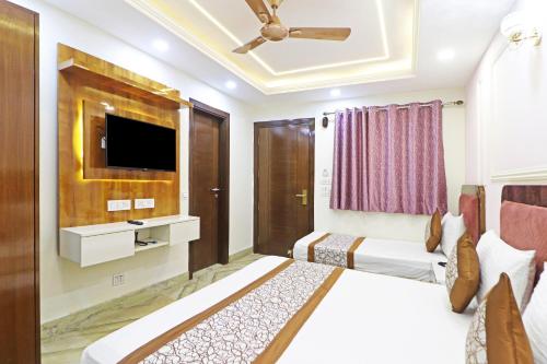 a hotel room with two beds and a flat screen tv at Frankstay By Hotel Samrat Residency 10 Mints Walking Distance Nizamuddin Railway Station in New Delhi