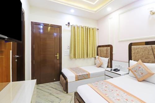 a hotel room with two beds and a television at Frankstay By Hotel Samrat Residency 10 Mints Walking Distance Nizamuddin Railway Station in New Delhi