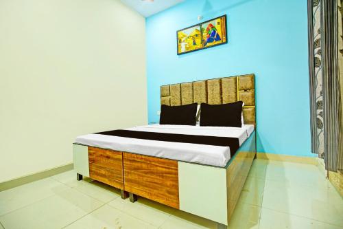 1 dormitorio con cama y pared azul en OYO Sirsa Hotel & Guest House, en Sirsa