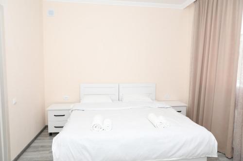a white bedroom with a white bed and a window at VST KHANOYAN'S HOTEL in Ninotsminda